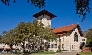 Historic Richardsonian stone church with tower and red tile roof. Preservation project by Heimsath Architects.