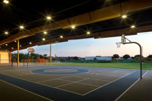 Open-air basketball court is adaptive reuse of old warehouse building. Renovations by Heimsath Architects and Architecture Plus.