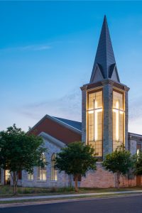 Steeple backlit at night with illuminated cross. Woodlawn Baptist Church, Austin Texas.