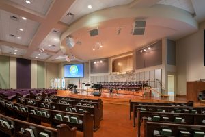 Sanctuary interior is designed with wide platform and raised baptistry for Woodlawn Baptist Church.