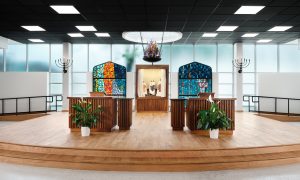 Bimah with arc, ner tamid, and recovered stained glass for transitional worship by Heimsath Architects.