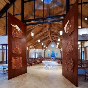 Carved wood doors with liturgical art depicting the Holy Trinity by George Hoelzeman.