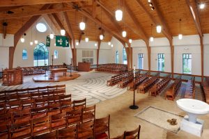 Church nave with flexible seating is both traditional and contemporary. Holy Trinity Episcopal by Heimsath Architects.