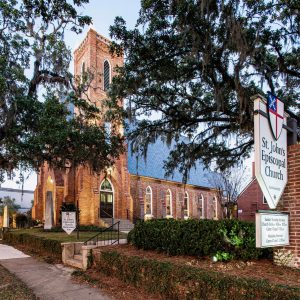 Restored historic brick church with oak trees in downtown Tallahassee. St. John’s Episcopal by Heimsath Architects.